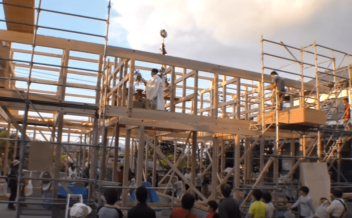 正在舉行上棟式的工地，中央白衣者為神道教的神職人員，其後方為工程人員。圖片來源