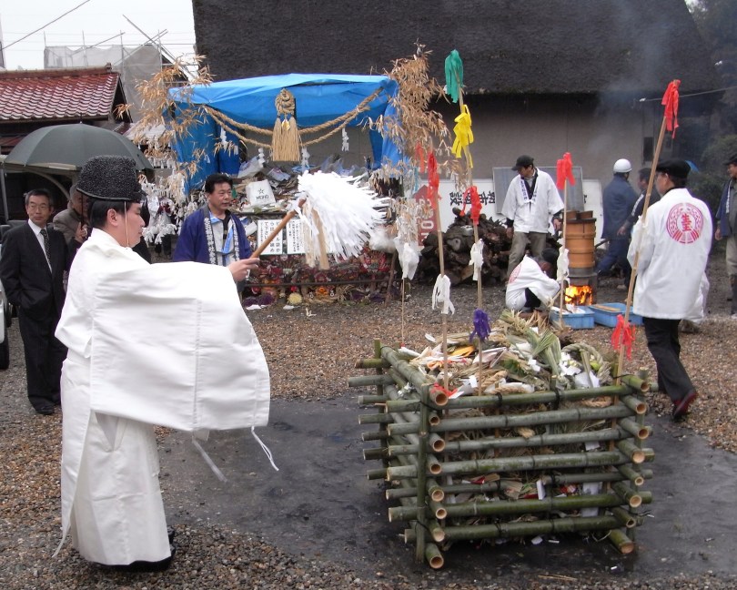 進行「左義長」中的神道教神職人員；注意他手中的「大幣」（消災驅邪的道具），此外「笏板」也是神職常用的另一種道具。圖片來源